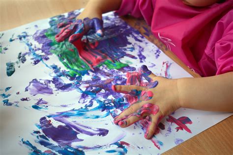 Kinderhände, die mit Fingerfarben malen