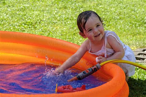 Ein Baby planscht fröhlich im Wasser mit seinen Eltern