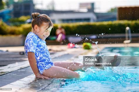 Kleines Kind lacht im Wasser bei einem Babyschwimmkurs.