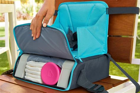 Eine vollgepackte Wickeltasche neben einem Handtuch und Spielzeug