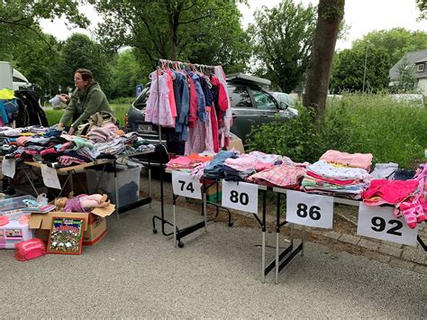 Eine Auswahl an Kinderkleidung und Spielzeug auf einem Flohmarktstand.