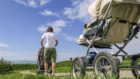 Eine Familie mit Kinderwagen auf einem gut ausgebauten Wanderweg in den Bergen