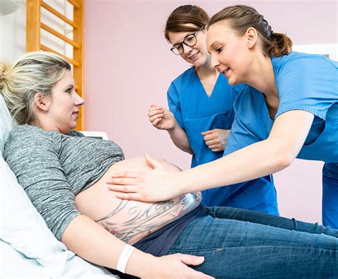 Eine Frau, die von einer Hebamme während der Schwangerschaftsvorsorge untersucht wird