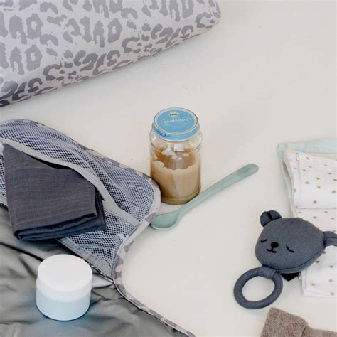 Eine Auswahl an Gastgeschenken für eine Babyparty, darunter kleine Säckchen, Mandeln und personalisierte Bänder.