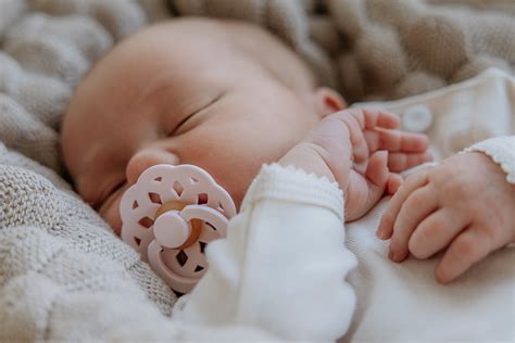 Baby, das glücklich einen Schnuller benutzt, mit Fokus auf Sicherheit und Altersempfehlung