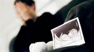 Symbolfoto: Ultraschallbild eines ungeborenen Kindes neben einem Kuscheltier